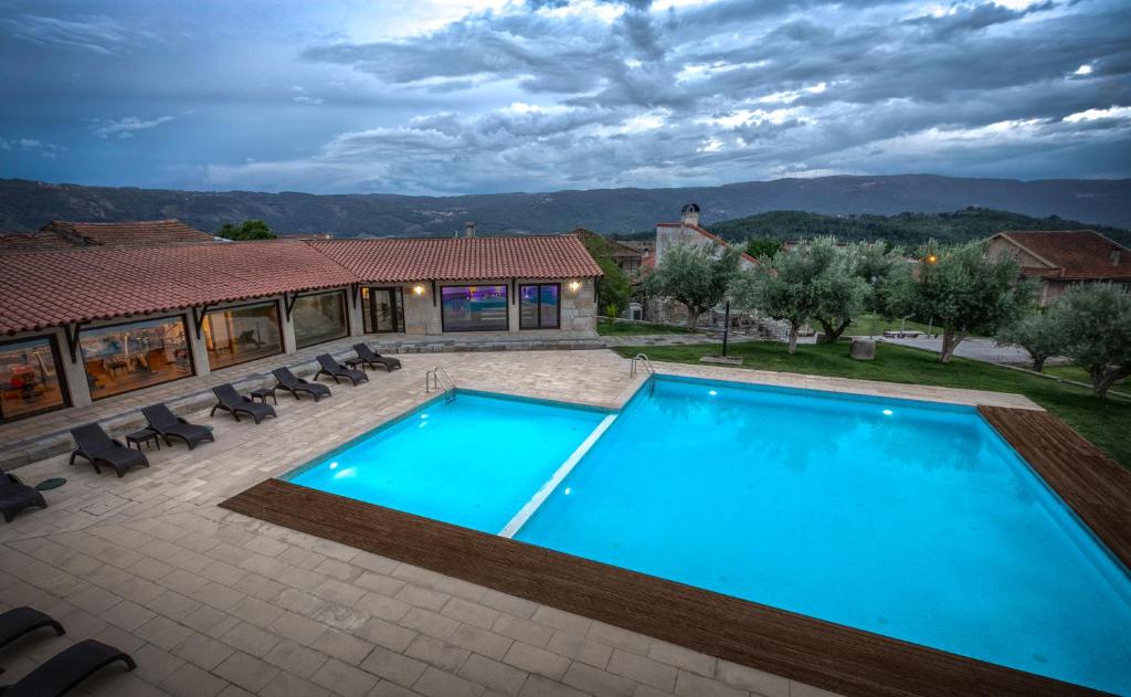 a swimming pool in a yard with a house at Quinta do Olival in Vilas Boas