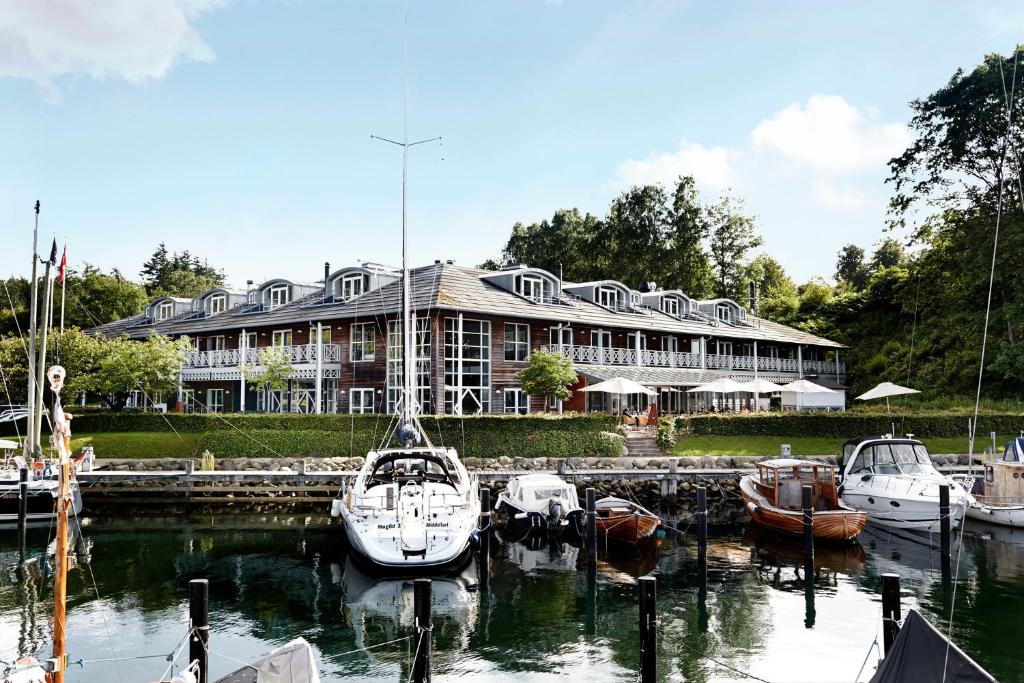 a large building with boats docked in a harbor at Comwell Kongebrogaarden in Middelfart