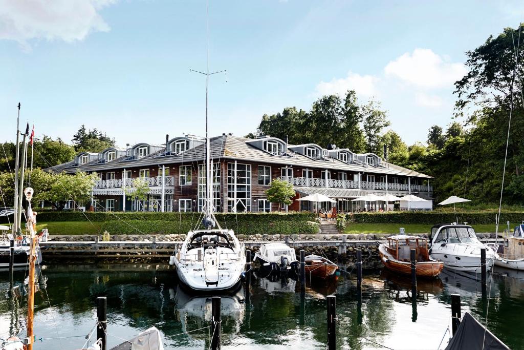 ein großes Gebäude mit in einem Hafen angedockten Booten in der Unterkunft Comwell Kongebrogaarden in Middelfart