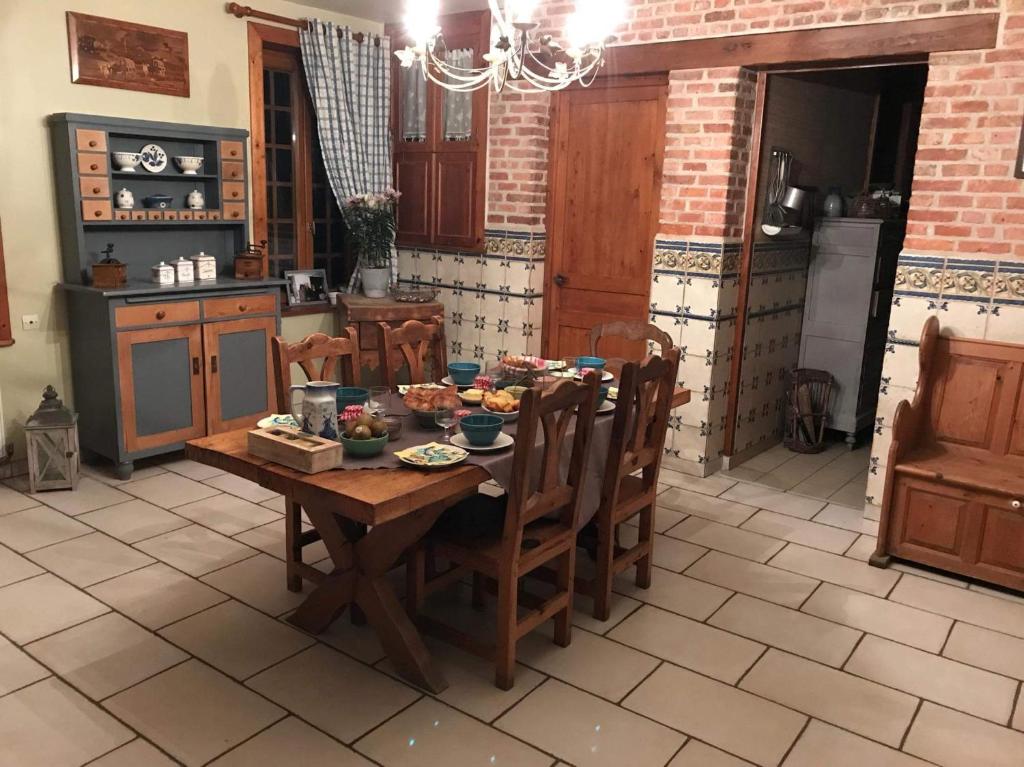 een keuken met een houten tafel en stoelen in een kamer bij Ferme de la Forterie in Verlinghem