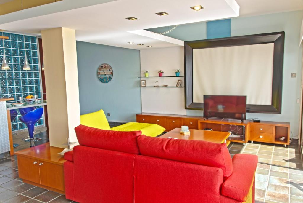 uma sala de estar com um sofá vermelho e uma mesa em Morpheus em Limassol