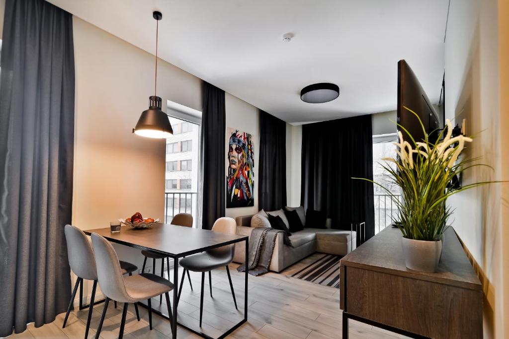 a dining room and living room with a table and chairs at City Center loft 2 in Kaunas