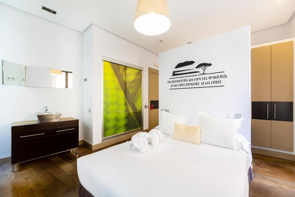 a bedroom with a white bed and a sink at Madrid House Rooms in Madrid
