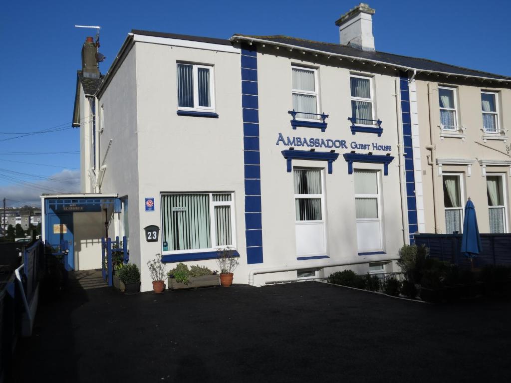 a white building with blue and white stripes on it at Ambassador Guest House Bed and Breakfast in Paignton