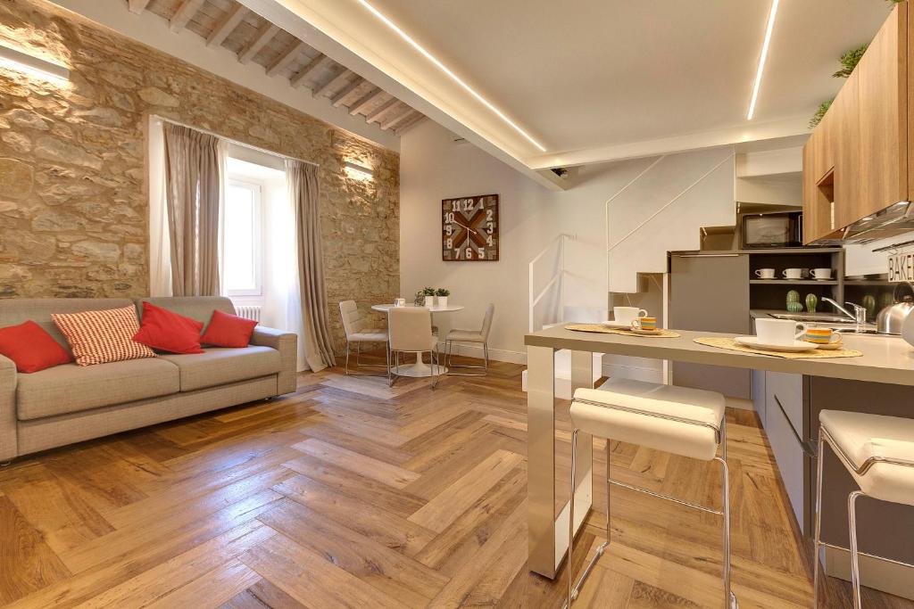 Mamo Florence - Mattonaia Apartment في فلورنسا: مطبخ وغرفة معيشة مع أريكة وطاولة