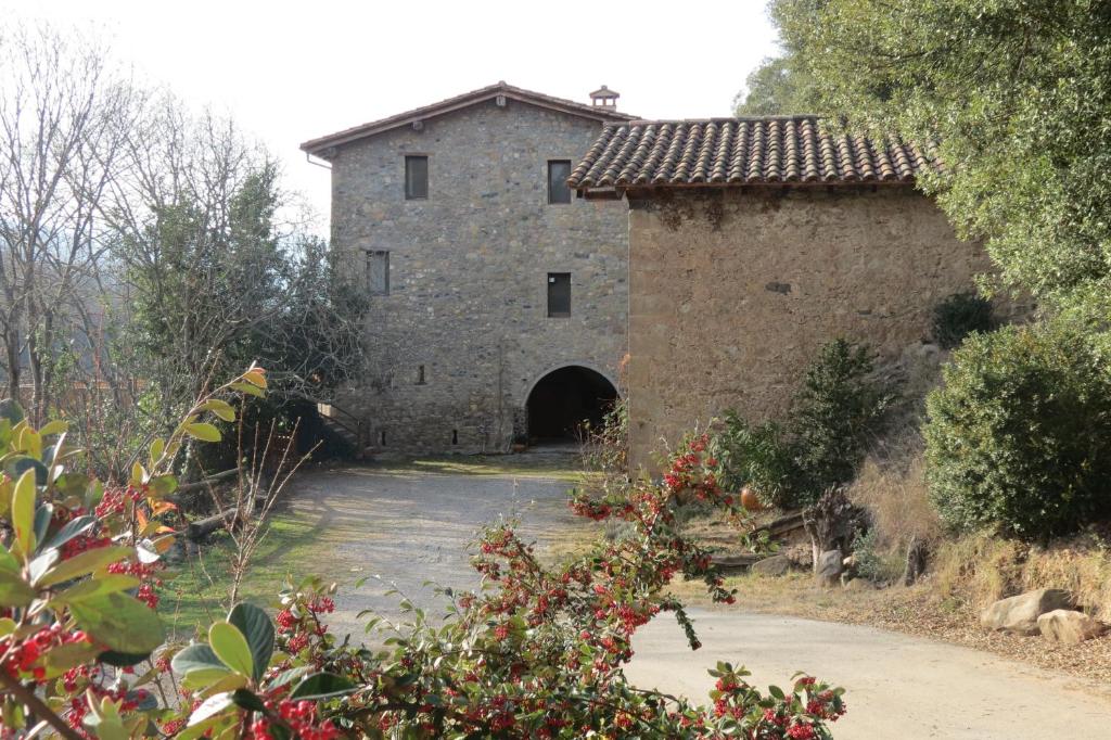 un antiguo edificio de piedra con un túnel en el fondo en Mas Colom, en Sant Joan les Fonts