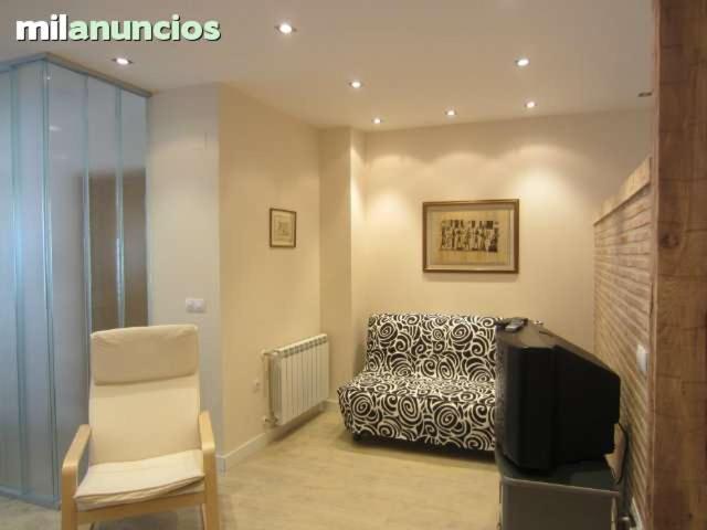 sala de estar con silla y TV en apartamento el mirador en Ezcaray