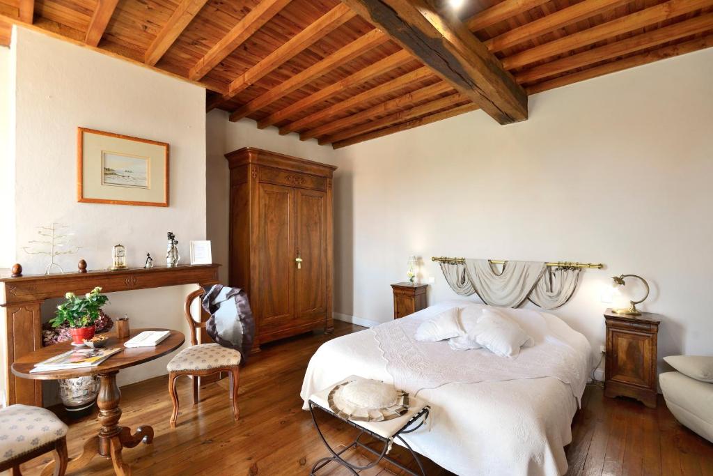 um quarto com uma cama, uma mesa e cadeiras em La Maison d'Anais em Vic-en-Bigorre