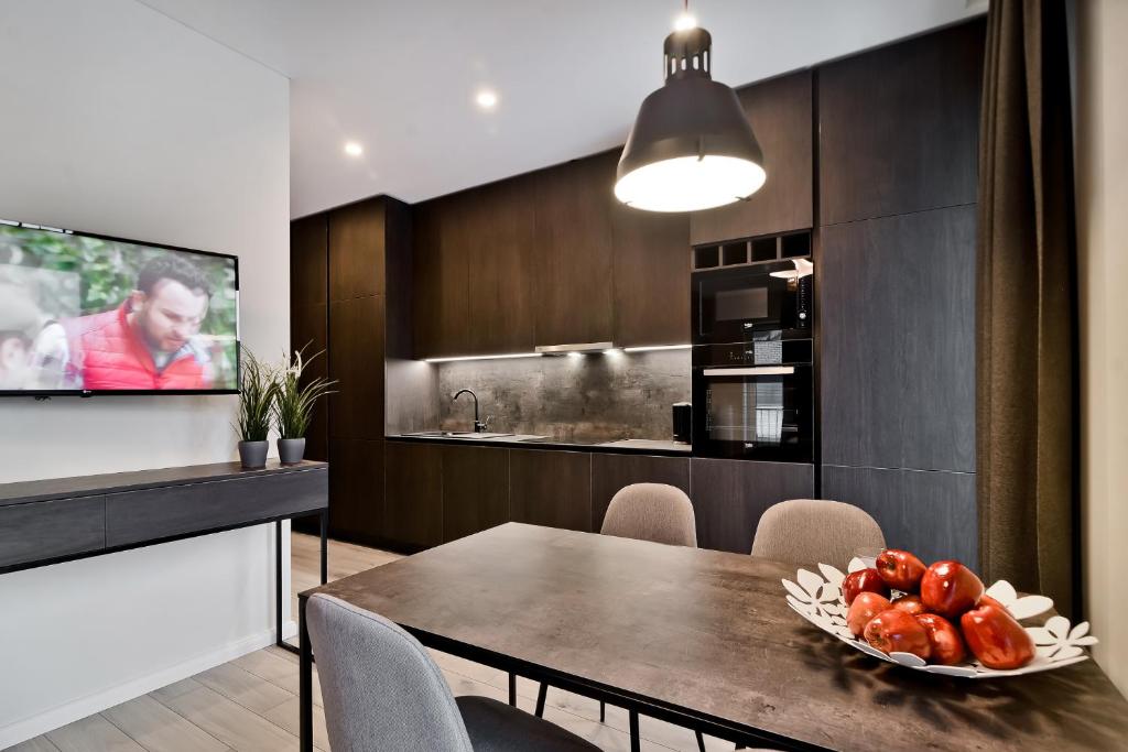 a kitchen with a table with a plate of fruit on it at City Center loft in Kaunas