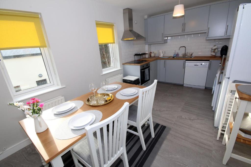 una cucina e una sala da pranzo con tavolo e sedie di Strand House 2 a Portstewart