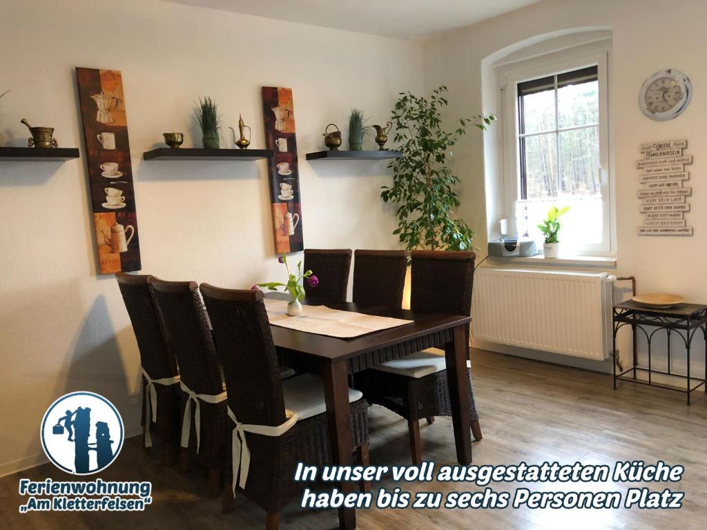 a dining room with a wooden table and chairs at Ferienwohnung "Am Kletterfelsen" in Krauschwitz