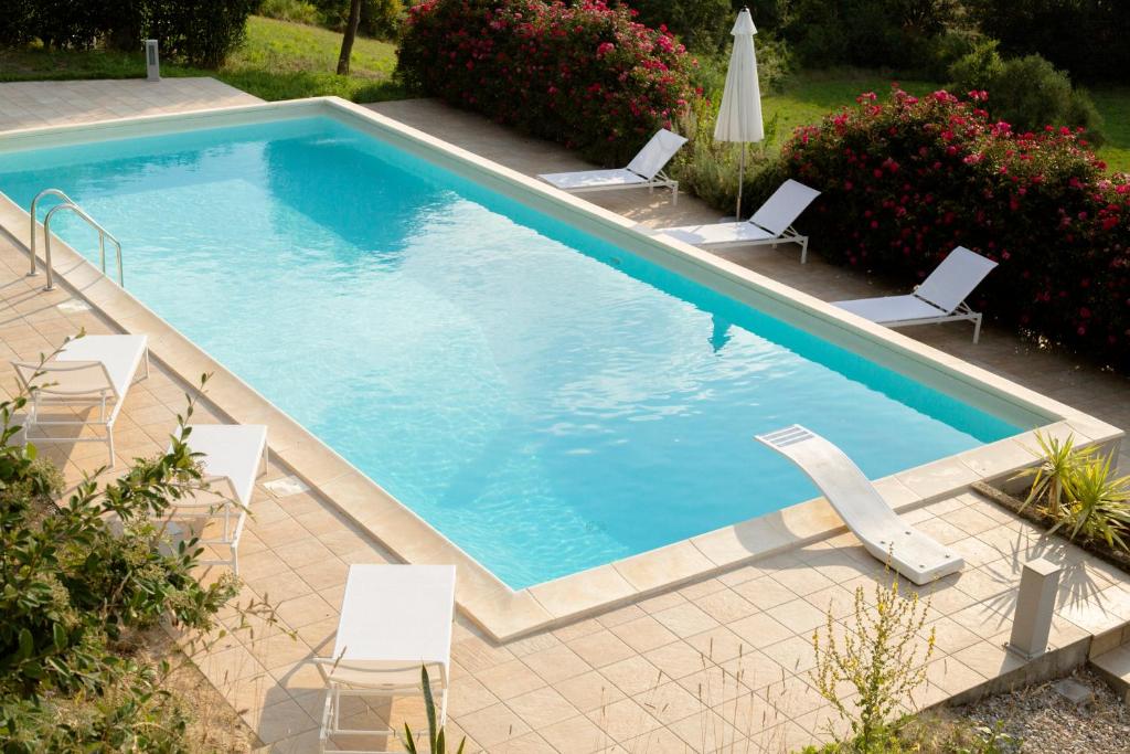 una piscina con sedie a sdraio e una piscina di San Rocco Country House a Pesaro