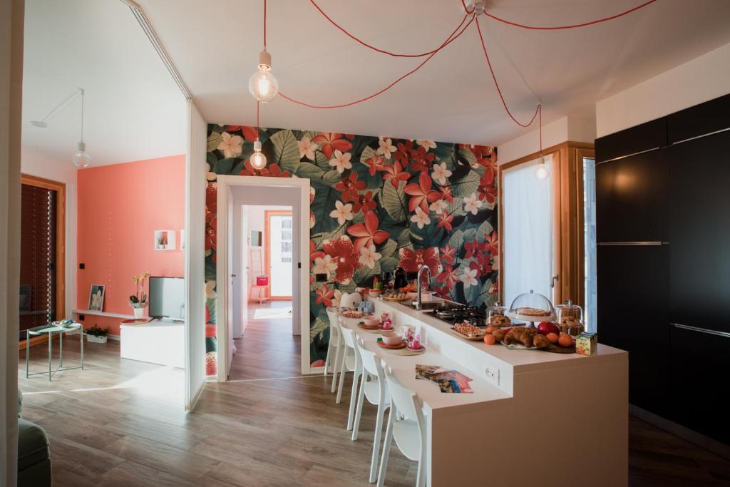 uma cozinha com uma mesa longa com cadeiras e uma parede floral em B&B LeTerrazze Boutique Hotel - Torino em Ciriè