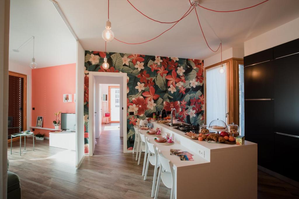 a kitchen with a long table with chairs and a floral wall at B&B LeTerrazze Boutique Hotel - Torino in Ciriè