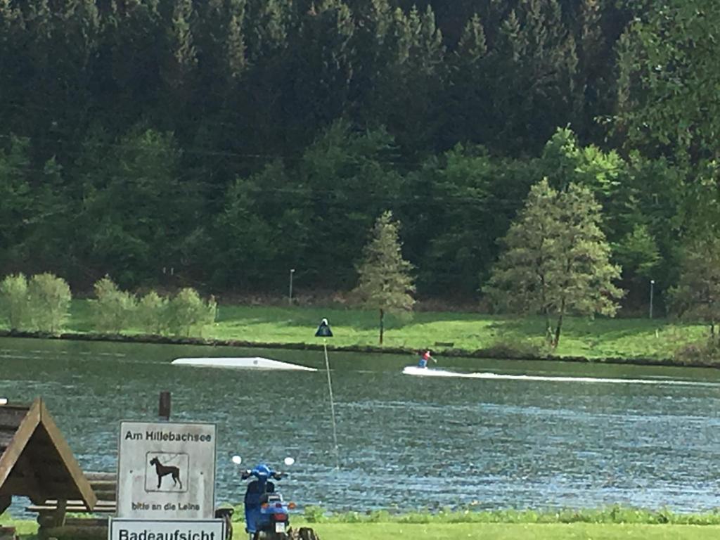 a person in a boat on a lake with a sign at Seeblick App Am Berg vor den Toren Winterbergs in Winterberg
