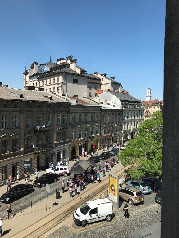 a city street with cars parked in front of buildings at Baker's street in Lviv
