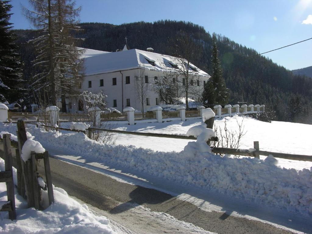 a fence covered in snow next to a building at Schloss Berg Klösterle in Zedlitzdorf