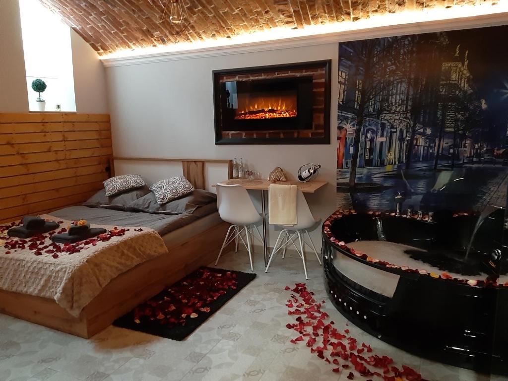 a bedroom with a bed and a tub and a fireplace at UNDERGROUND Jacuzzi Rooms in Krakow