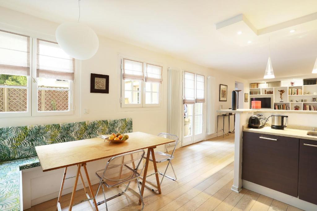 une cuisine et une salle à manger avec une table et des chaises dans l'établissement Apartment Champs Elysées by Studio prestige, à Paris