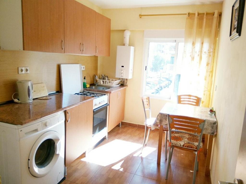 a kitchen with a washing machine and a table with chairs at Apartment in Valencia in Valencia