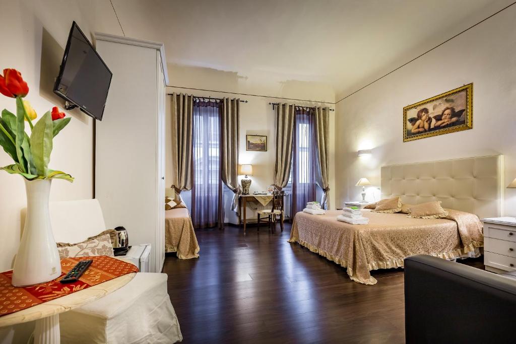 a bedroom with two beds and a television in it at B&B De Biffi in Florence