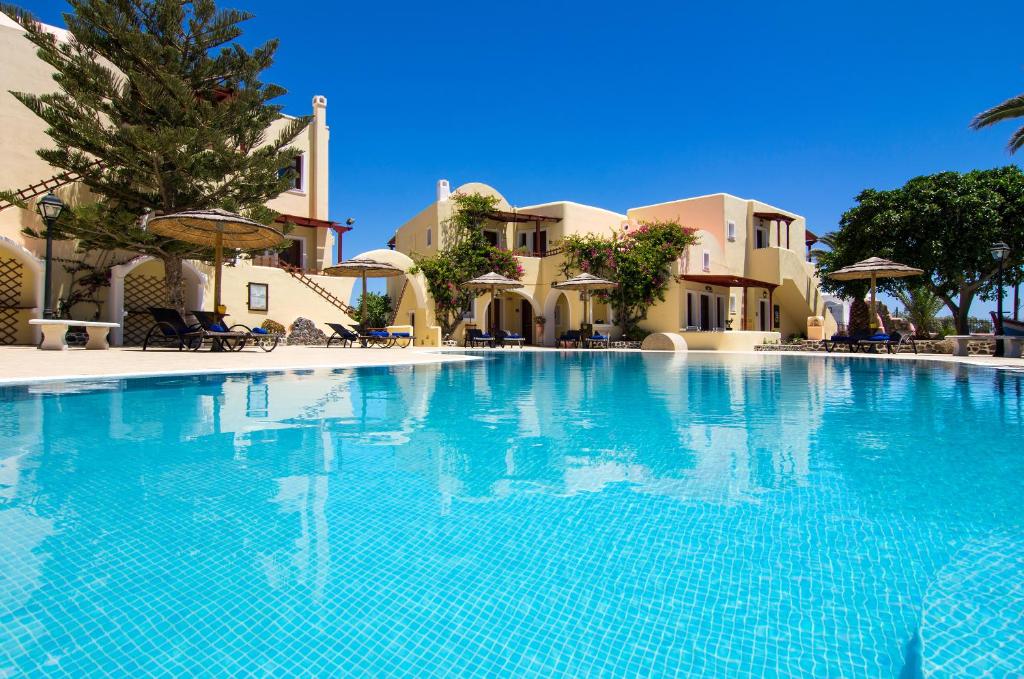 a large swimming pool in front of a villa at Smaragdi Hotel in Perivolos