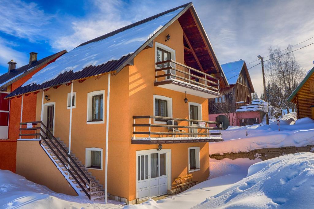 a house with snow on the ground at Apartmani Mila in Žabljak