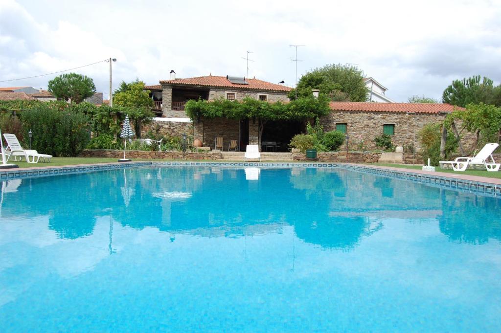 une grande piscine bleue en face d'une maison dans l'établissement Casa dos Araújos, à Frechas