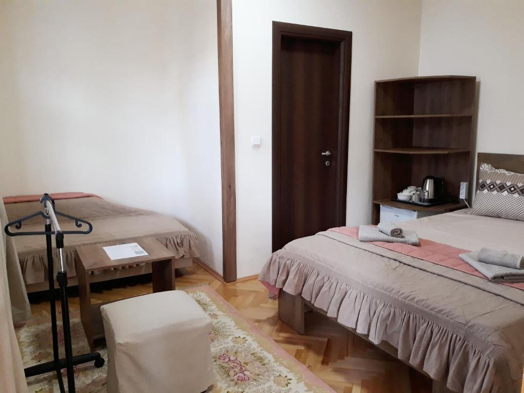Habitación con 2 camas, mesa y silla en Villa Domina, en Gevgelija