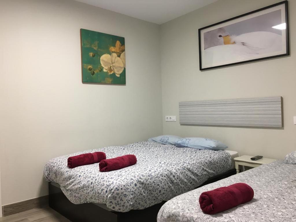 two beds in a room with red pillows on them at Albergue Logroño Centro in Logroño