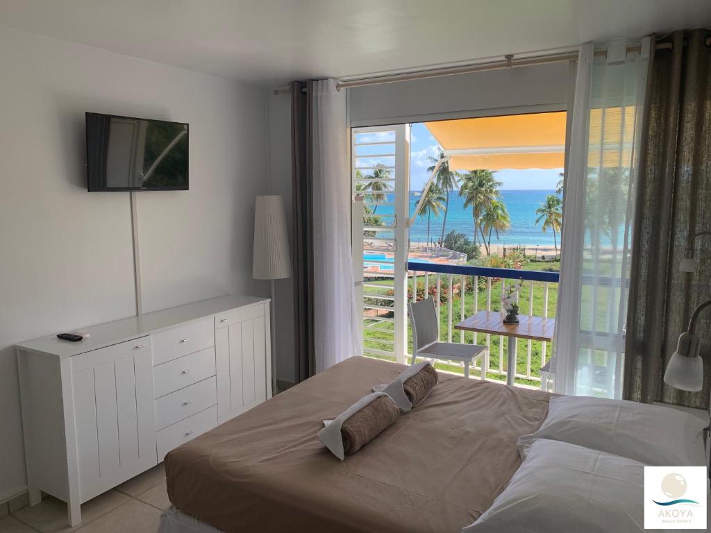 a bedroom with a bed and a view of the ocean at Pana Beach in Le Gosier