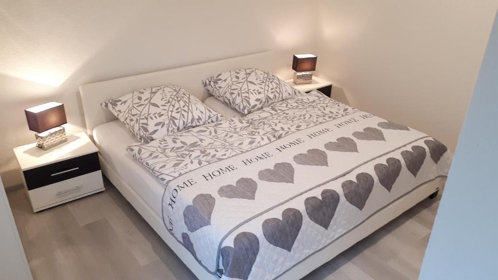 ein Schlafzimmer mit einem Bett mit zwei Nachttischen in der Unterkunft Ferienhaus Blütenzauber in Norddeich in Norddeich