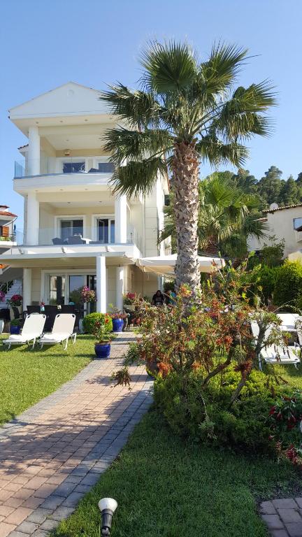 a palm tree in front of a building at SUN RESIDENCE Exclusive Seaside Suites in Polychrono