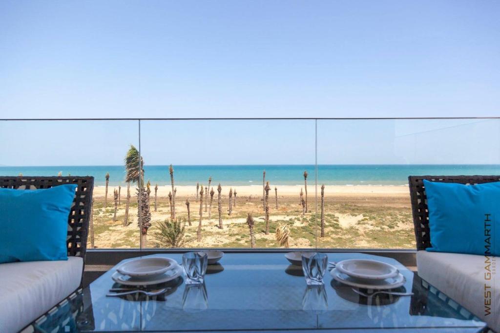 a dining table with a view of the beach at West ghammarth garden1 in Borj el Khessous