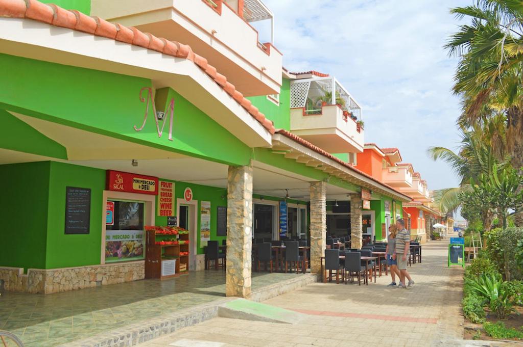 um restaurante com um edifício verde e laranja em Djasal Moradias em Santa Maria