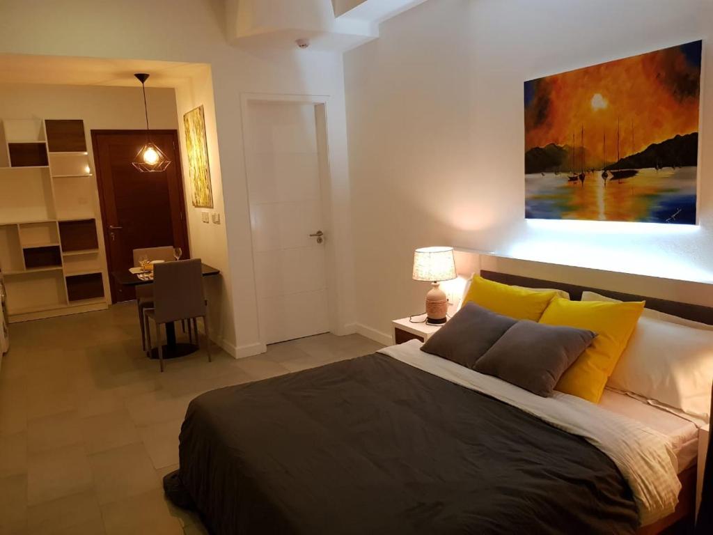 a bedroom with a bed and a painting on the wall at Studio 103, Ebene Square in Ebene