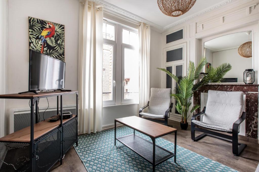 een woonkamer met 2 stoelen en een tafel bij Cosy appartement proche Gares in Lille