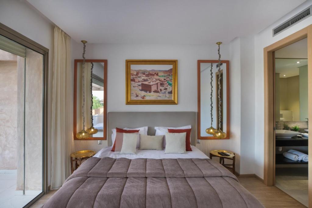 a bedroom with a large bed and two mirrors at Chez Maya in Marrakesh