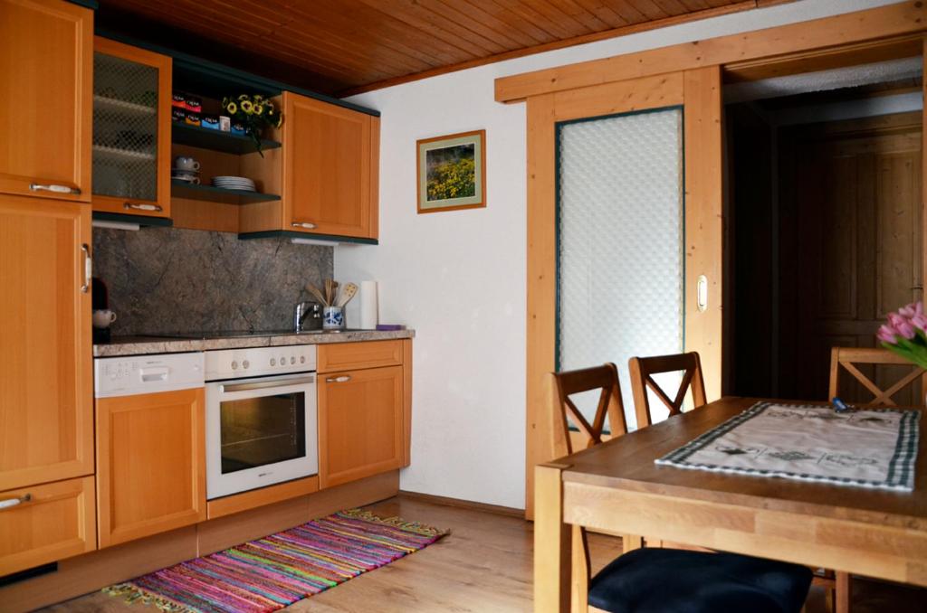 una cocina con armarios de madera y una mesa con comedor. en Ferienwohnung Blockheide, en Gmünd