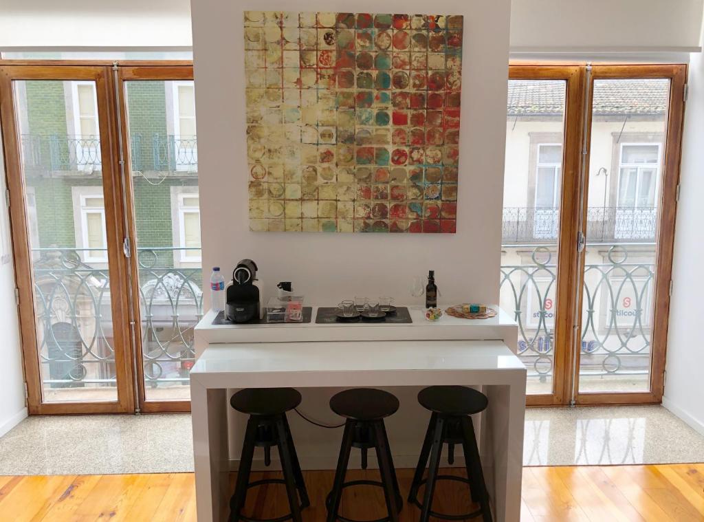 eine Küche mit einer Theke mit zwei Stühlen in der Unterkunft Invictus Place in Porto