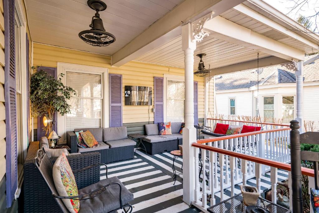 une terrasse couverte avec des canapés et des chaises sur une maison dans l'établissement Montgomery Inn BnB, à Versailles