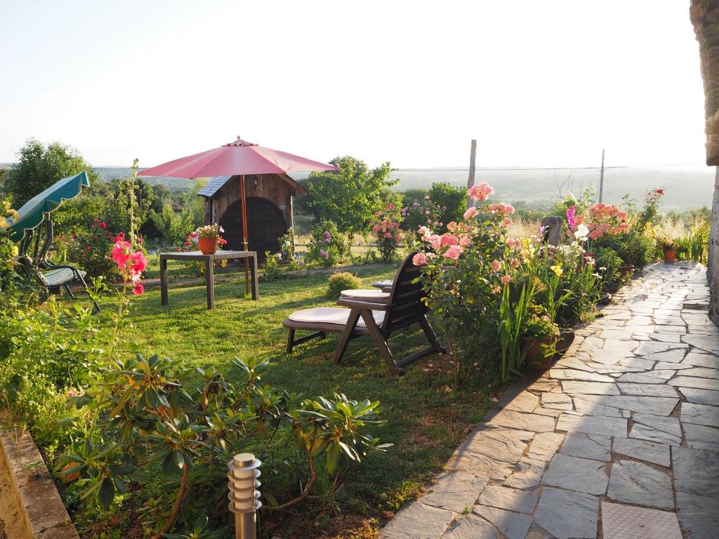 un jardín con un banco, una mesa y algunas flores en Casa Dos Fuelles en Ourense