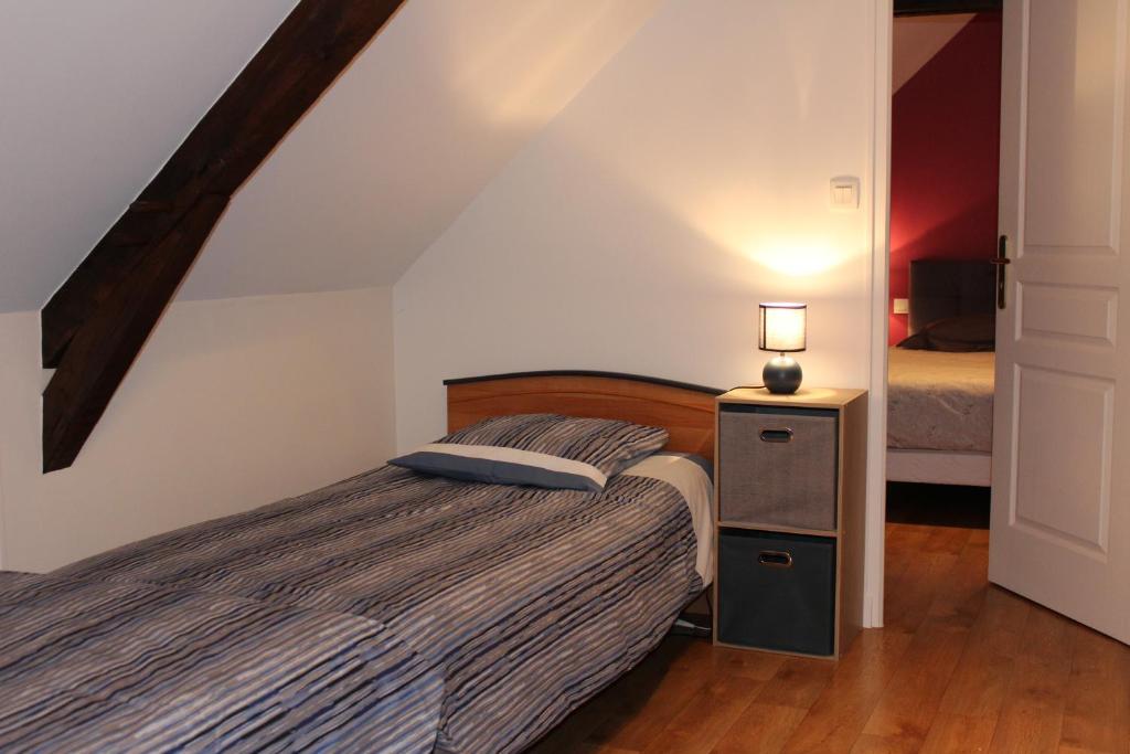 a bedroom with a bed and a lamp on a night stand at Gîte La Loussaudrie in Pontmain