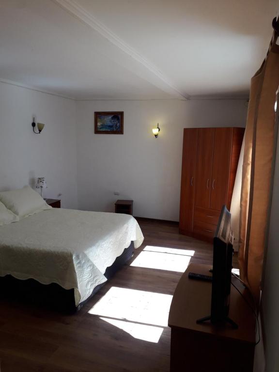a bedroom with a bed and a desk with a television at Mediterraneo Apartments (Recreo) in Viña del Mar
