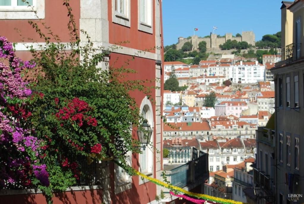 een uitzicht op de stad met gebouwen en bloemen bij Casa Bonecos Rebeldes in Lissabon