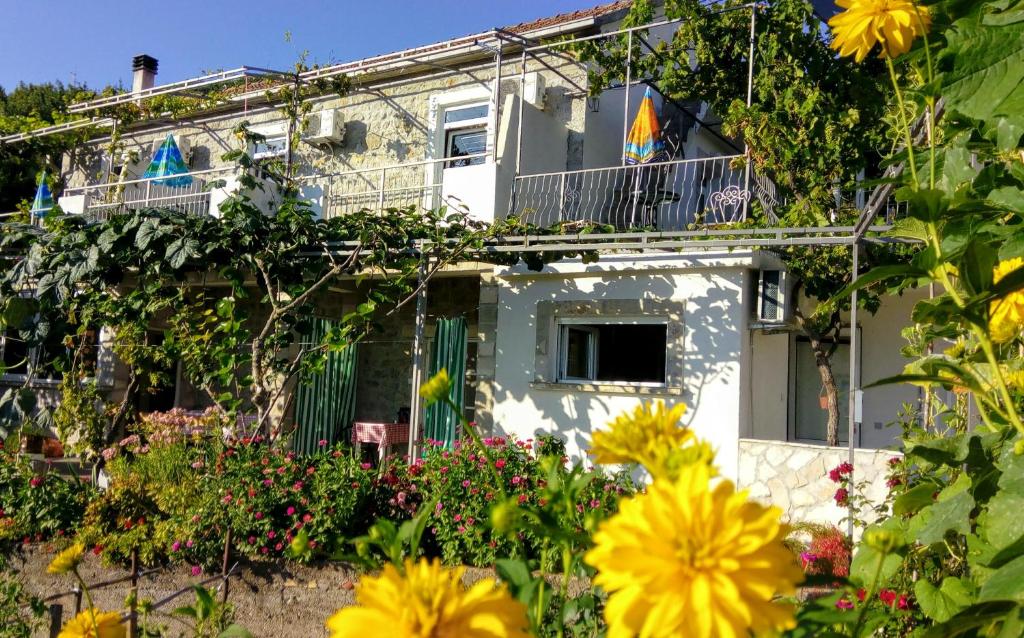 una casa con flores delante en Apartmani Bosco, en Tivat