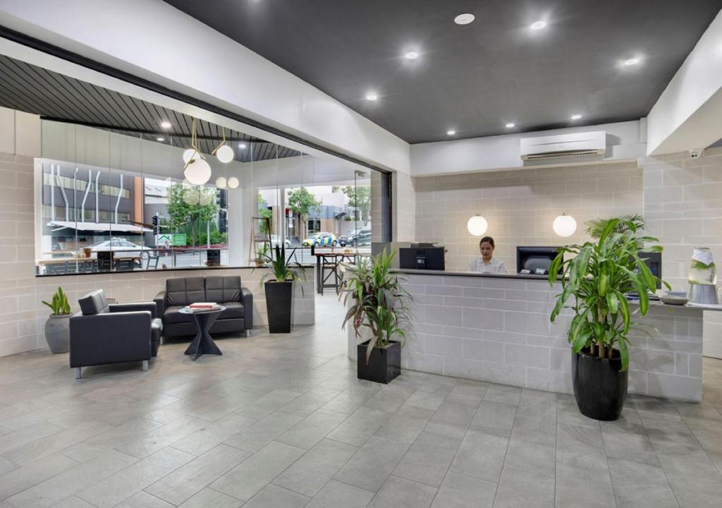 a lobby of a restaurant with potted plants at The Metropolitan Spring Hill in Brisbane