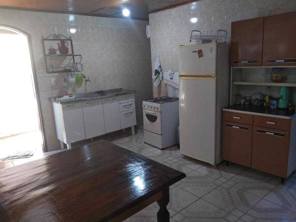 a kitchen with a refrigerator and a table in it at Casa Maringá in Visconde De Maua