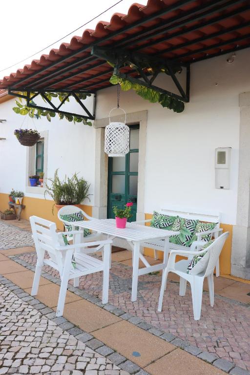 una mesa blanca y sillas en un patio en Casa da Ti Bia, en Setúbal