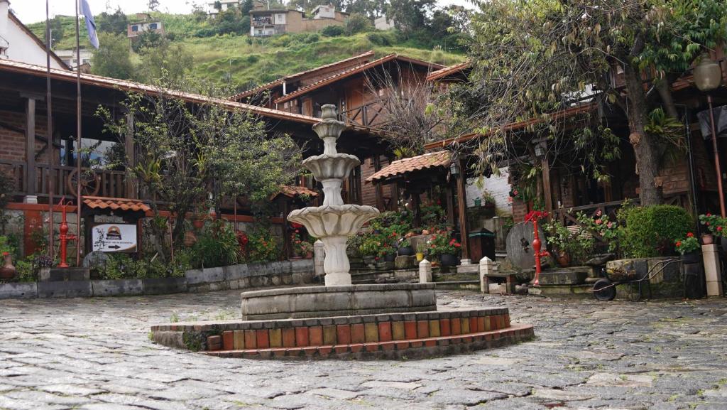 a fountain in a courtyard in front of a building at La Rustica Hotel in Guaranda